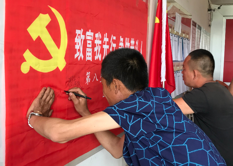 欧肯河八队主题党日活动党员承诺带头致富签名 张萌摄.jpg